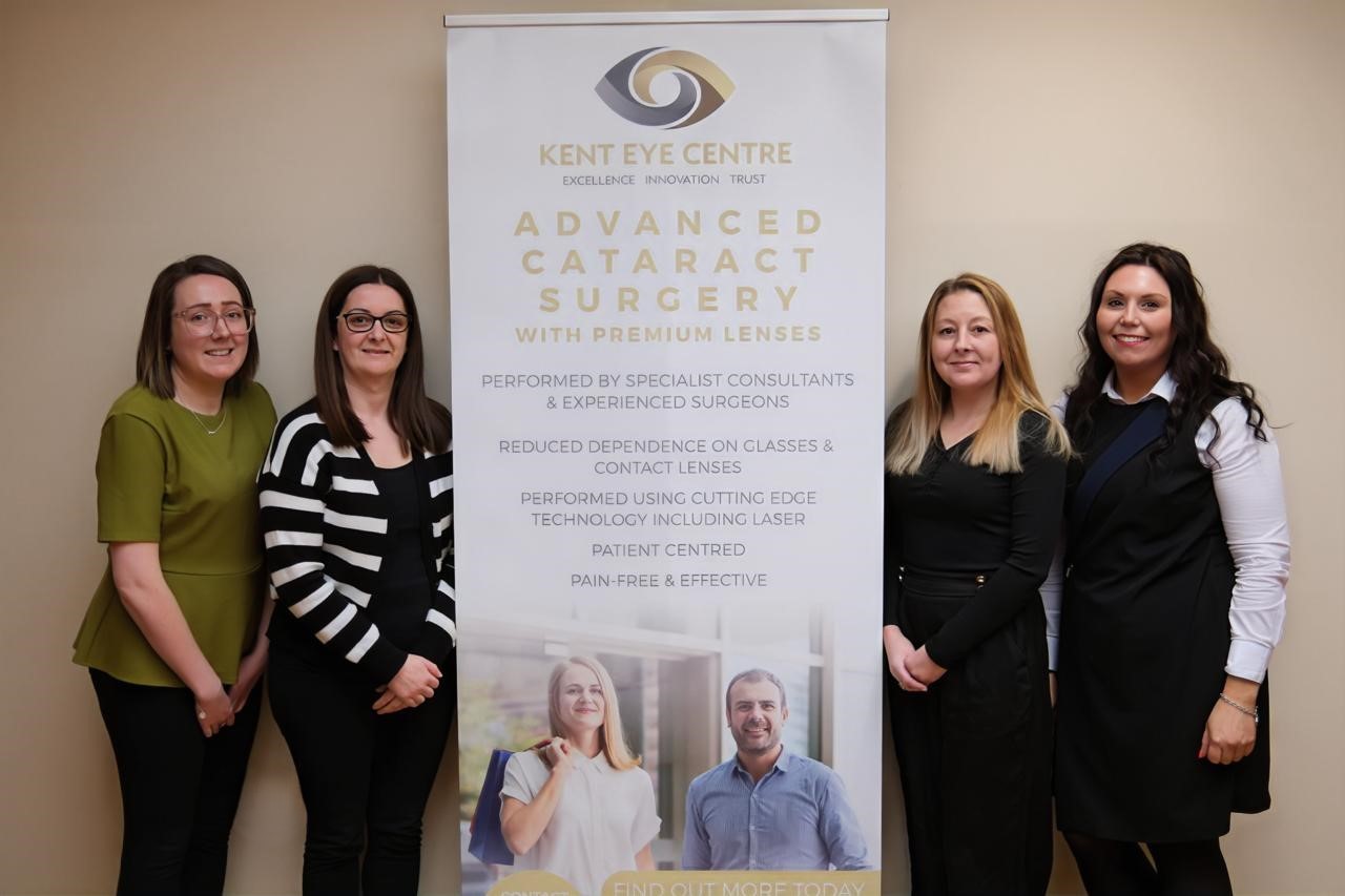 Team photo showing 4 members of staff with one of our advertising signs in the middle